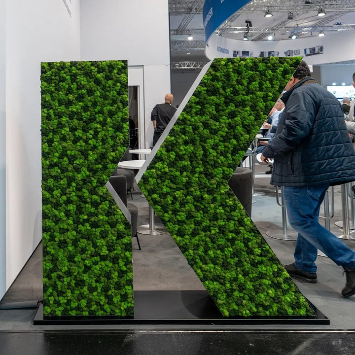 Massgefertigtes Mooslogo an Messestand